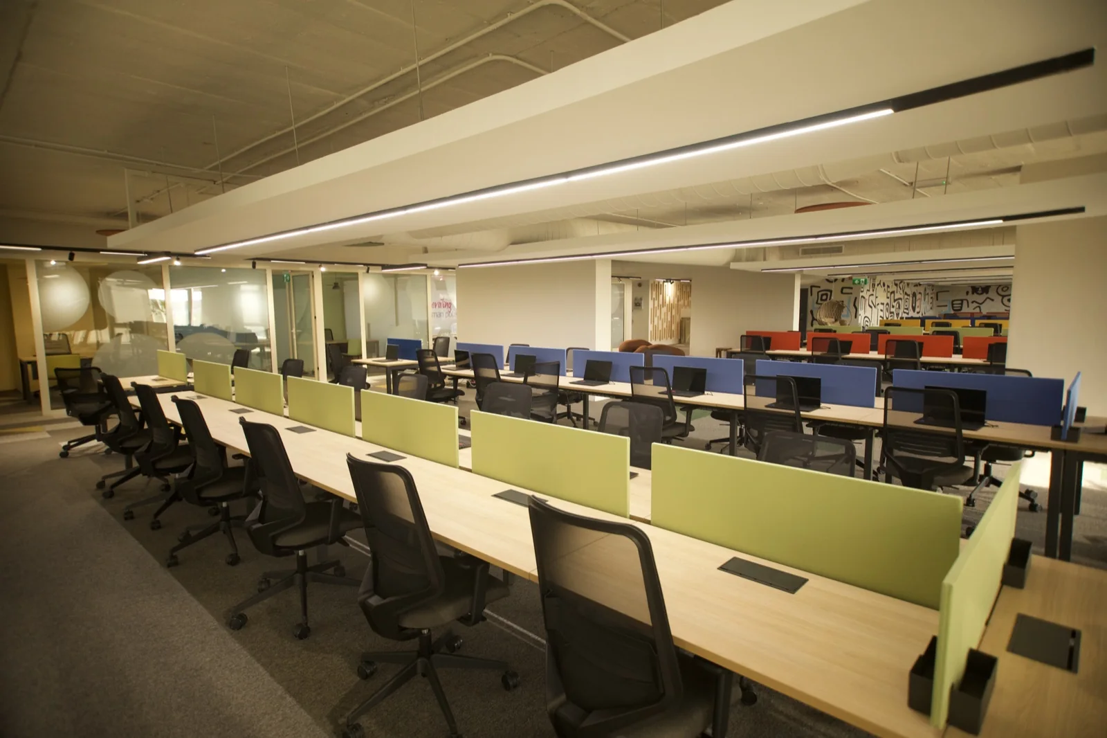 Open-plan office with long desks and screens, from Enzo Spaces