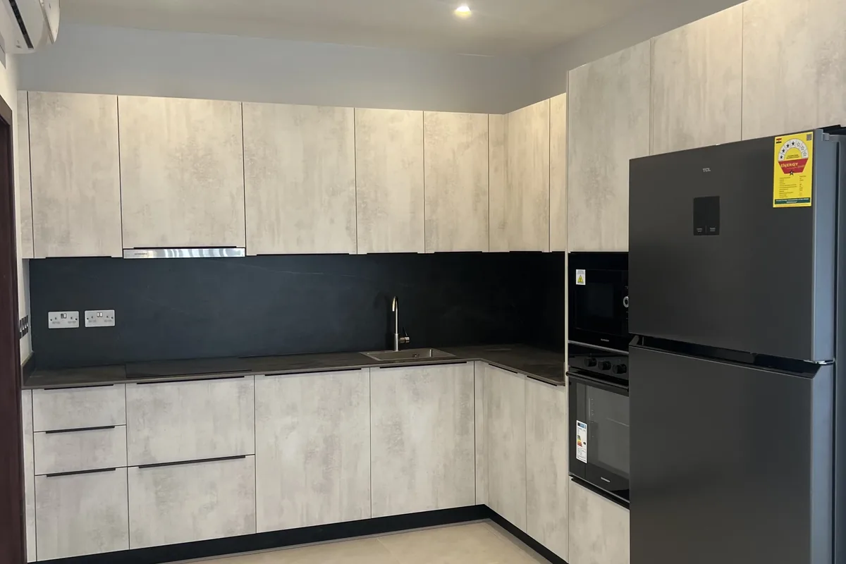 Fitted grey kitchen cabinetry with a black splashback